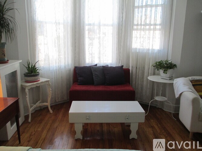 A living room with a red couch and a white coffee table.