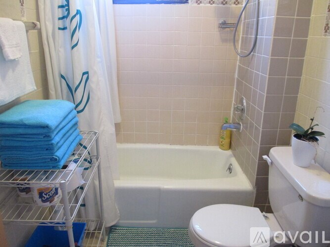 A bathroom with a white toilet, a white sink, a white bathtub, and a white shower curtain.