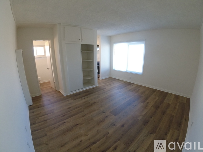 A room with wooden flooring and white walls.