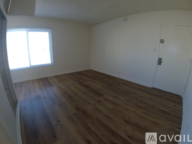 A room with wooden flooring and a white door.