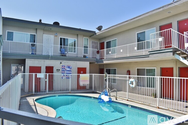 A small pool is surrounded by a balcony with a railing.