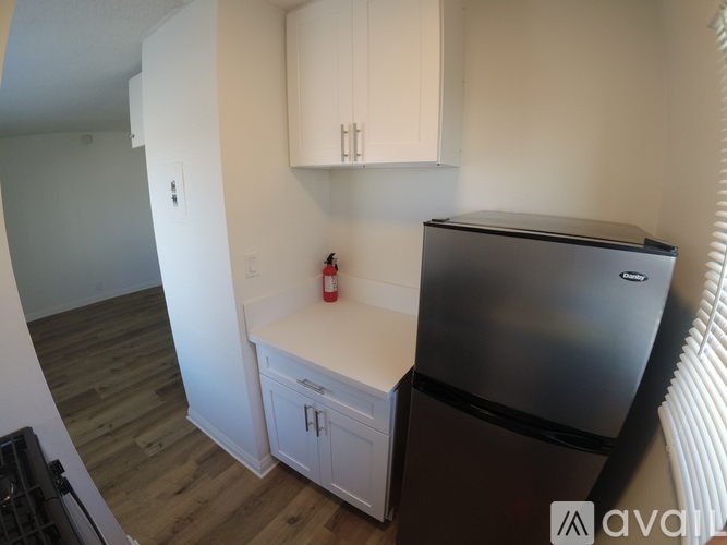 A kitchen with a stainless steel refrigerator and white cabinets.