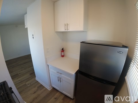 A kitchen with a stainless steel refrigerator and white cabinets.