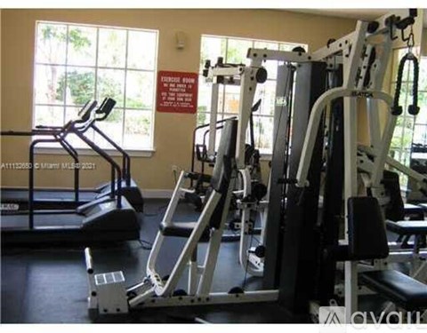 A gym with a treadmill and a weight machine.