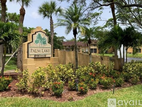 A sign that says Palm Lake in front of some houses.