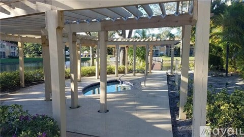 A pool area with a pergola and a pool table.