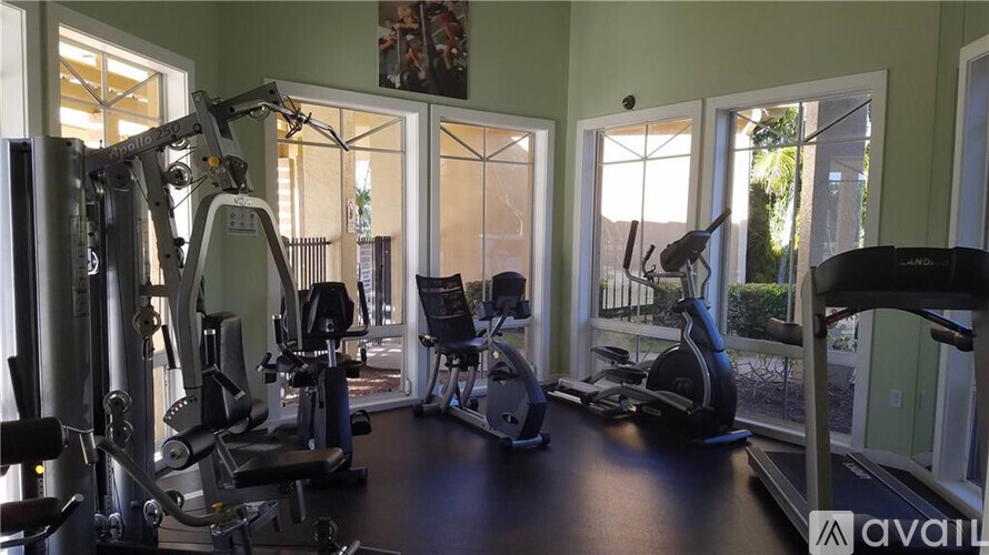 A gym with a variety of equipment including a treadmill, weights, and a stationary bike.