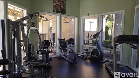 A gym with a variety of equipment including a treadmill, weights, and a stationary bike.