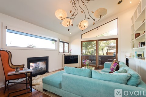 A living room with a blue couch and a fireplace.