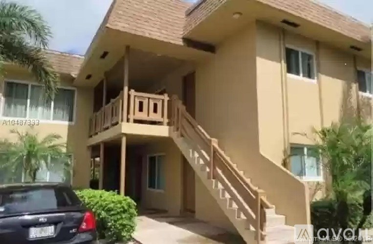 A two-story house with a balcony and stairs leading to the second floor.