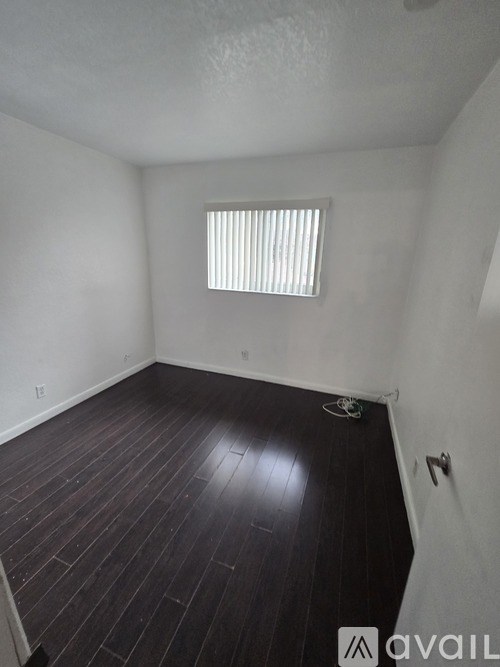 A room with a window and wooden flooring.