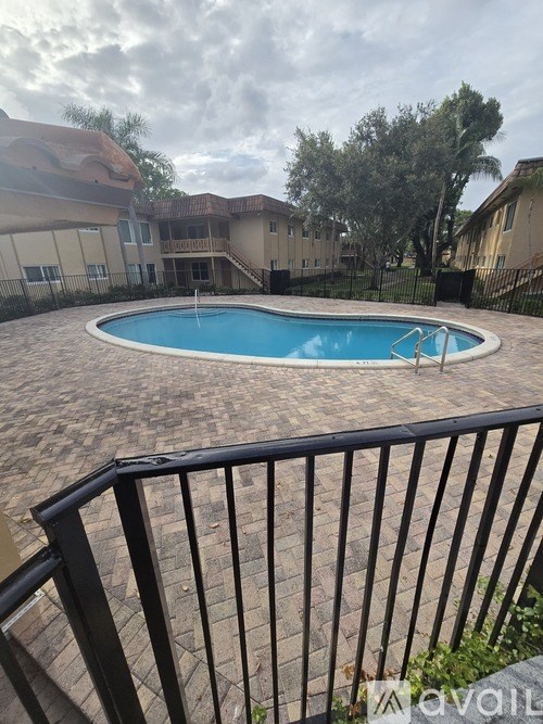 A black metal fence surrounds a small pool.