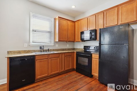 A kitchen with black appliances and wooden cabinets.