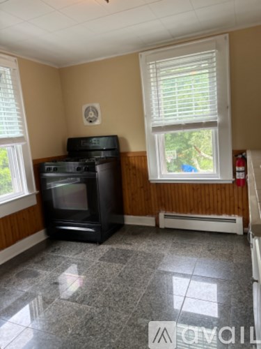 A black oven and stove in a kitchen with a window.