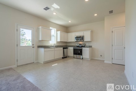 A kitchen with white cabinets and appliances is available for rent.