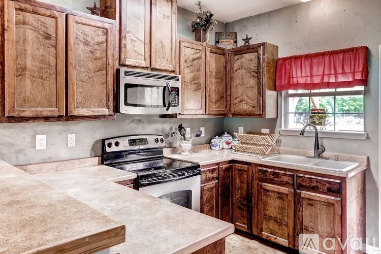 A kitchen with wooden cabinets and a white microwave above the stove.