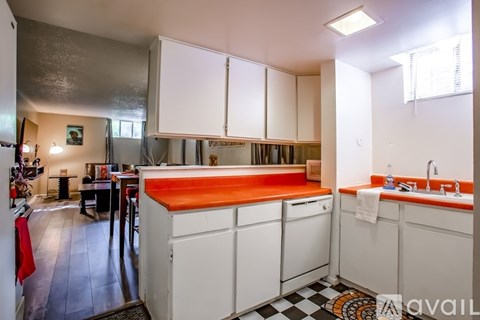 A kitchen with white cabinets and a black and white checkered floor.