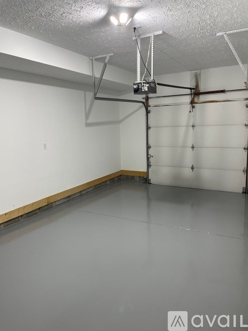 A spacious garage with a concrete floor and white walls.