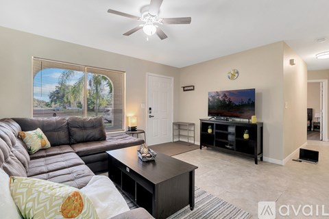A living room with a grey couch and a black coffee table.