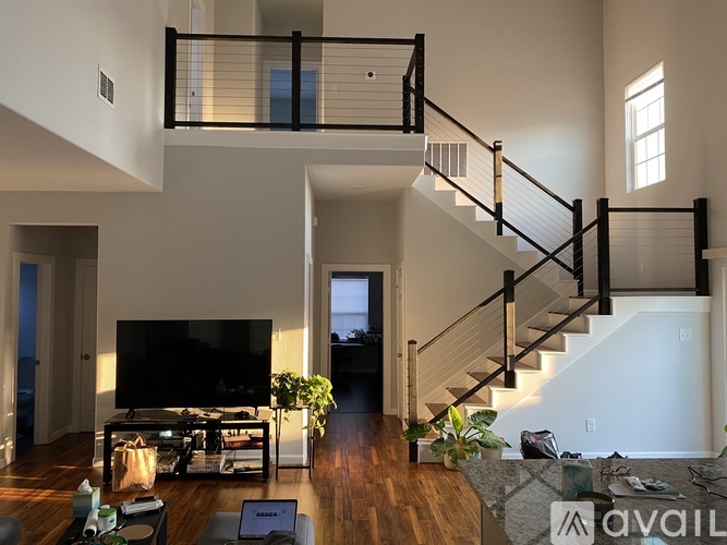 A living room with a staircase and a television.