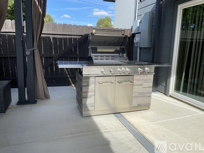 A modern outdoor kitchen with a grill and sink.