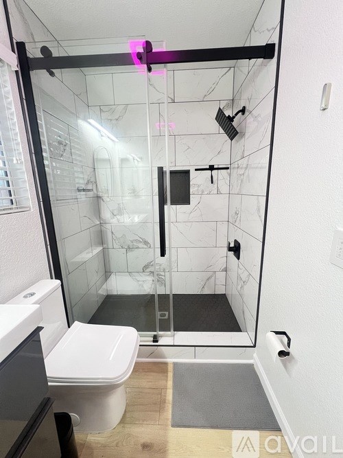 A bedroom with a bed, desk, and window.