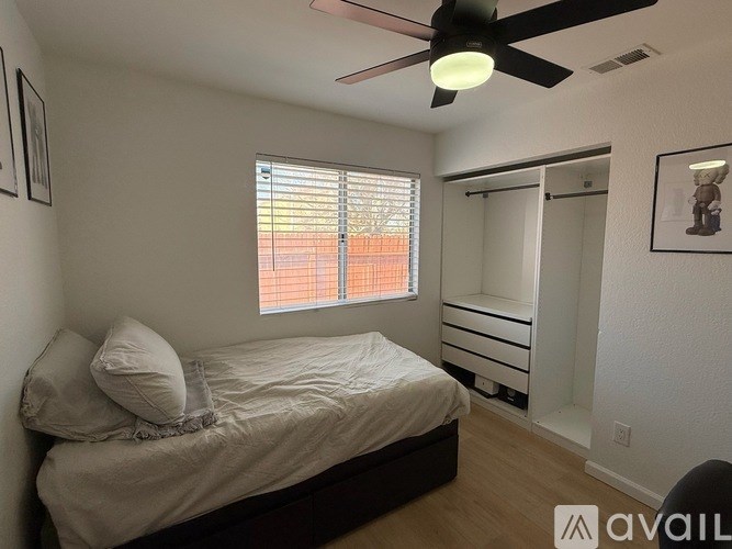A bedroom with a bed, dresser, and window with blinds.