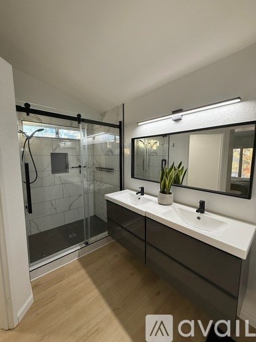 A bathroom with a glass shower door and a white countertop.