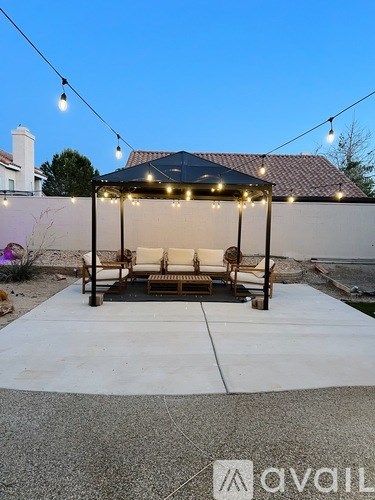 A patio area with a gazebo and string lights.