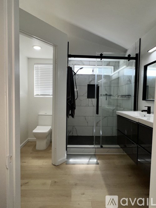 A bathroom with a toilet, sink, and shower.