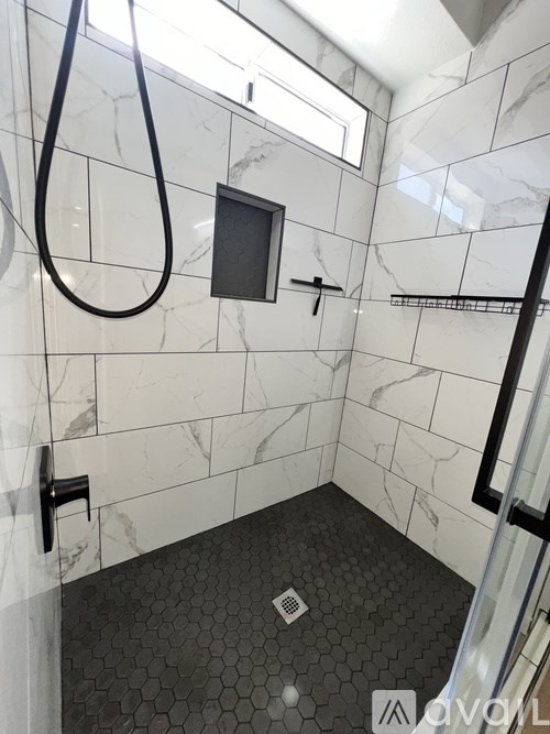 A bathroom with a marble tile floor and walls.