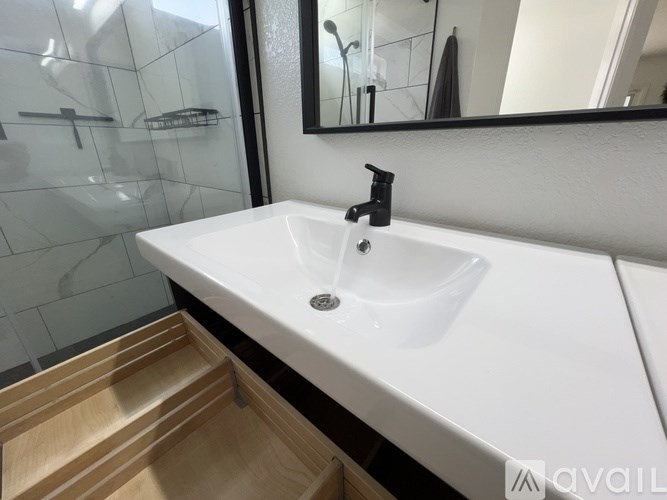 A white sink with a black faucet in a bathroom.