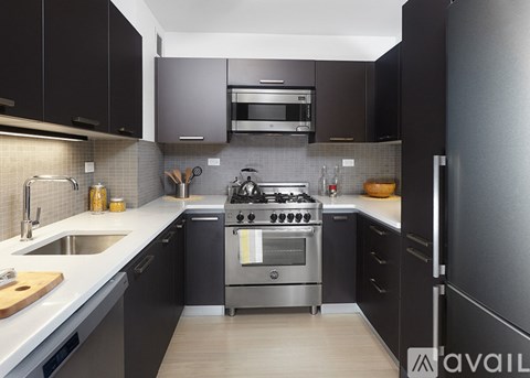 A modern kitchen with a stainless steel stove and black cabinets.