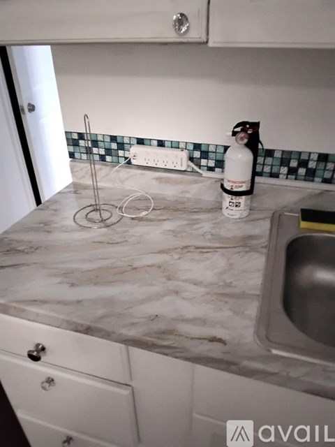A kitchen counter with a bottle and a ring on it.