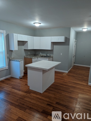 A kitchen with white cabinets and a white island.