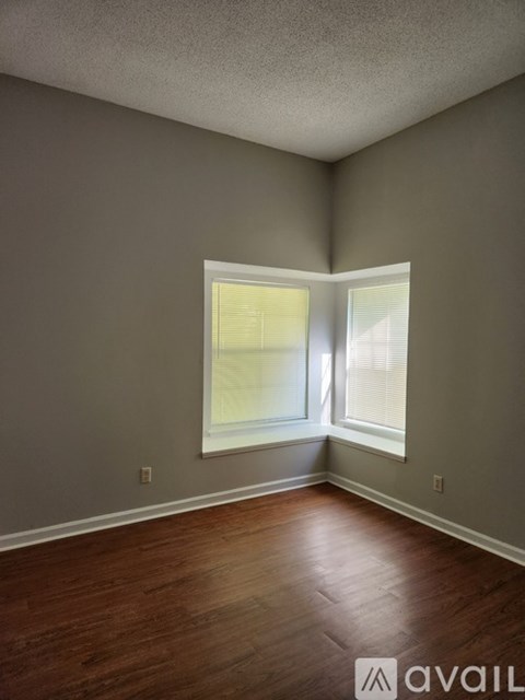 A room with a window and wooden flooring.