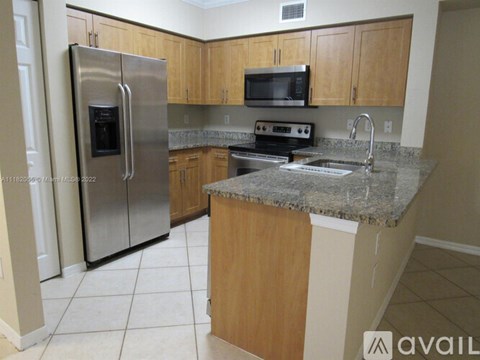 A kitchen with a granite countertop and stainless steel appliances.