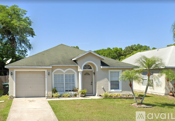 A house with a white garage door and a green roof.
