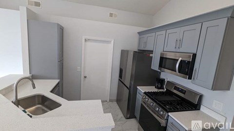 A kitchen with a sink, stove, and refrigerator.