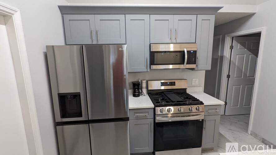 A kitchen with a stainless steel refrigerator, microwave, oven, and cabinets.