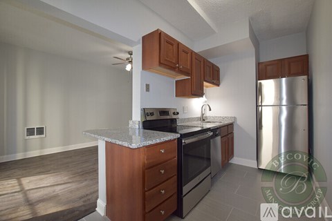 A kitchen with wooden cabinets and a stainless steel refrigerator.