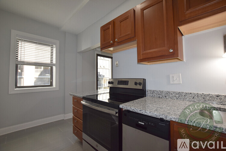 A kitchen with a granite countertop and wooden cabinets.