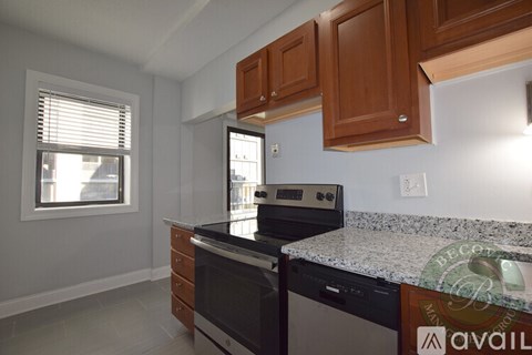 A kitchen with a granite countertop and wooden cabinets.