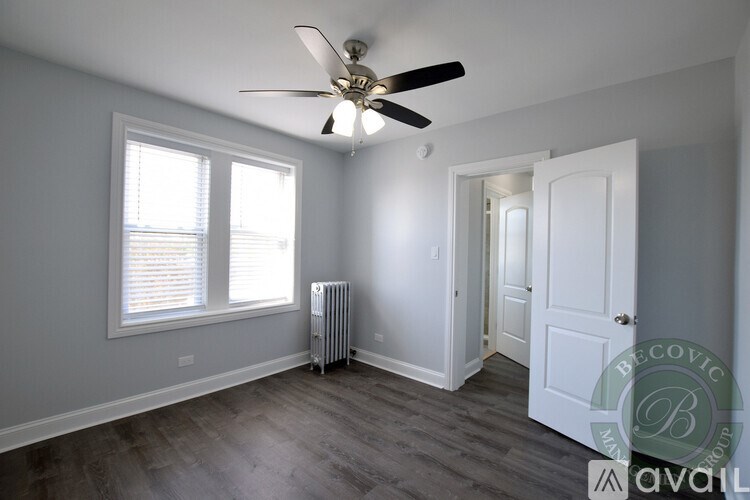 A room with a ceiling fan and a window with blinds.