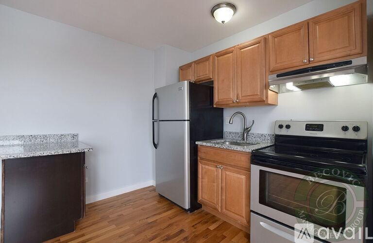 A kitchen with wooden cabinets and a stainless steel refrigerator.