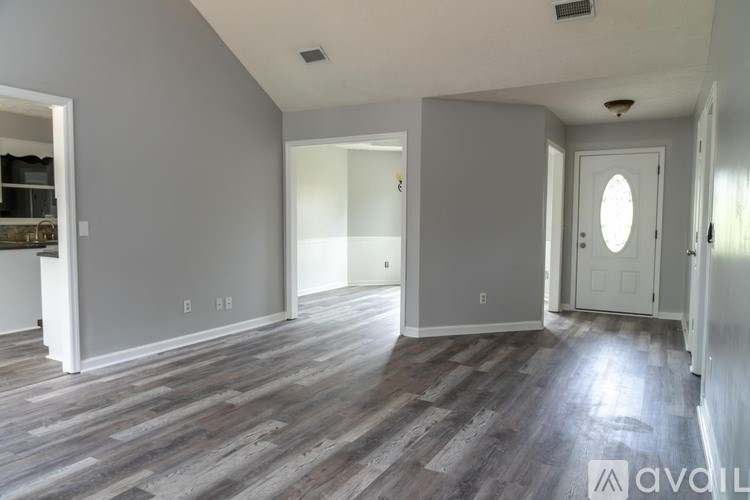 A room with wooden flooring and white walls is available for rent.