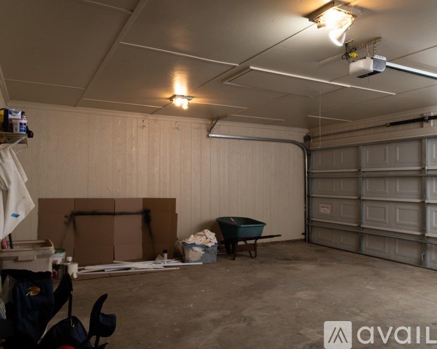 A spacious garage with a wheelbarrow and a box on the floor.