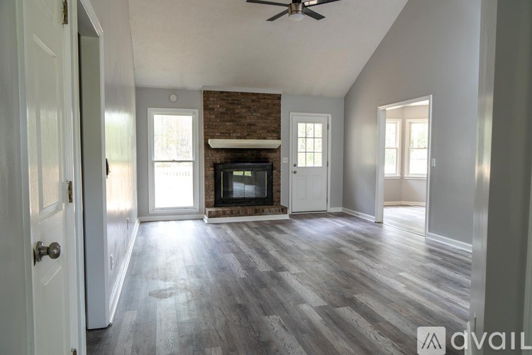 A living room with a fireplace and a ceiling fan.