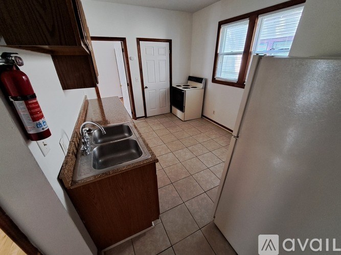 A kitchen with a sink and a refrigerator.
