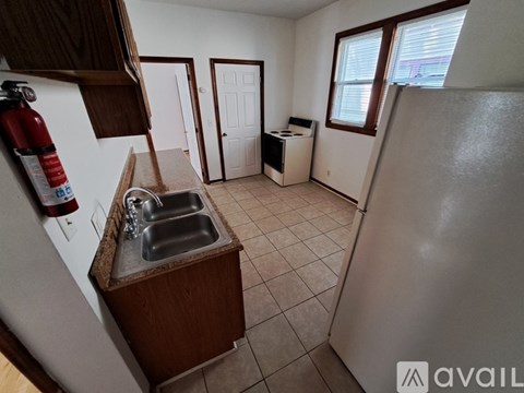 A kitchen with a sink and a refrigerator.